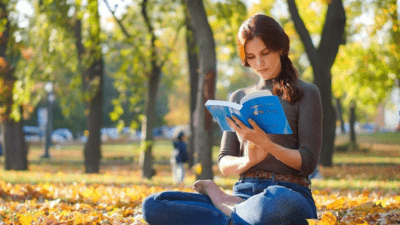 Девушка, практикующая Фалунь Дафа, читает книгу.