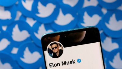Профиль Илона Маска в Twitter на смартфоне, размещённый на печатных логотипах Twitter, 28 апреля 2022 года.(Dado Ruvic/Reuters)