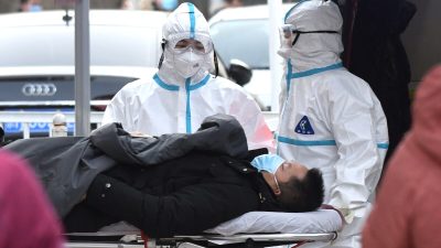 Медицинские работники доставляют пациента в инфекционную клинику в больнице Пекина 13 января 2021 года. (Greg Baker/AFP via Getty Images)
