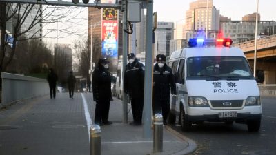 Полиция следит за дорогой у реки Лянма, где 29 ноября 2022 года в Пекине прошли недавние акции протеста по поводу жертв смертельного пожара, а также против жёстких ограничений, введённых Китаем в связи с COVID-19.(Noel Celis/AFP via Getty Images)
