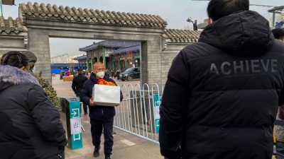 Мужчина несёт урну с прахом близкого человека в крематории в Пекине, 20 декабря 2022 года. (Noel Celis/AFP via Getty Images)
