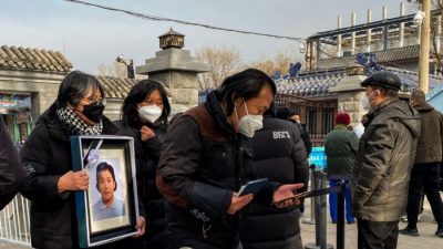 Родственники с траурным фото в крематории в Пекине 20 декабря 2022 года. (Noel Celis/AFP via Getty Images)