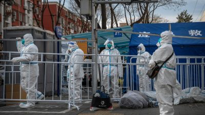Работники эпидемического контроля стоят у закрытого района в Пекине 29 ноября 2022 г. (Kevin Frayer/Getty Images)