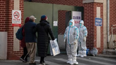 Медицинский персонал ждёт, чтобы помочь пациенту в клинике, где лечат пациентов с COVID-19 в Пекине, 21 декабря 2022 года. (Kevin Frayer/Getty Images)
